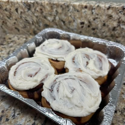 Iced cinnamon rolls in a foil pan.