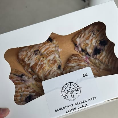 A box of blueberry scones with lemon glaze.